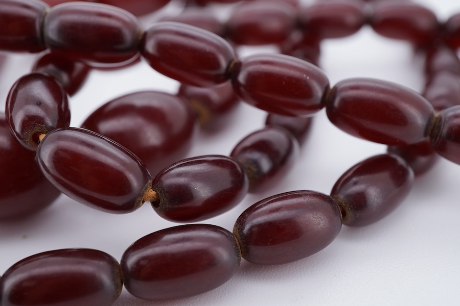 A cherry-coloured bakelite 'amber' necklace, composed of graduated oval beads measuring approximately 1.1-3cm, length 76cm, gross weight 66 grams, Condition: good, minor wear